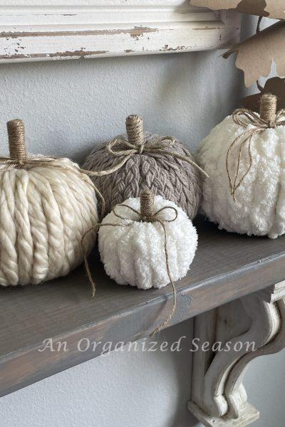 Four pumpkins made from different types of yarn.