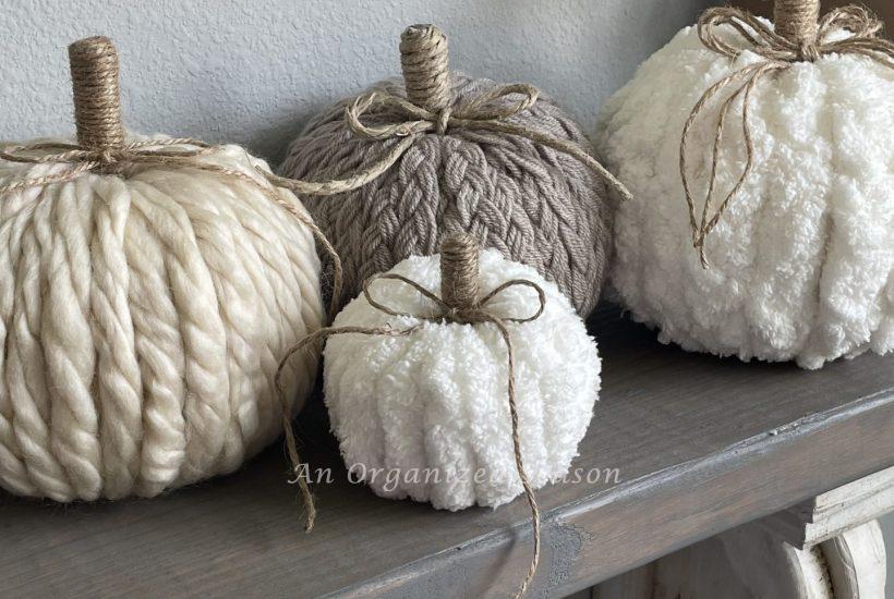 Four pumpkins made from different types of yarn.