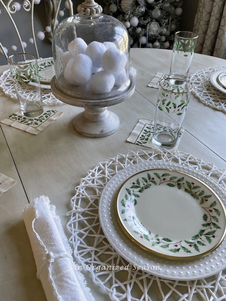 A kitchen table set with white and cream dishes with holly leaves adds a little bit of Christmas to the kitchen.