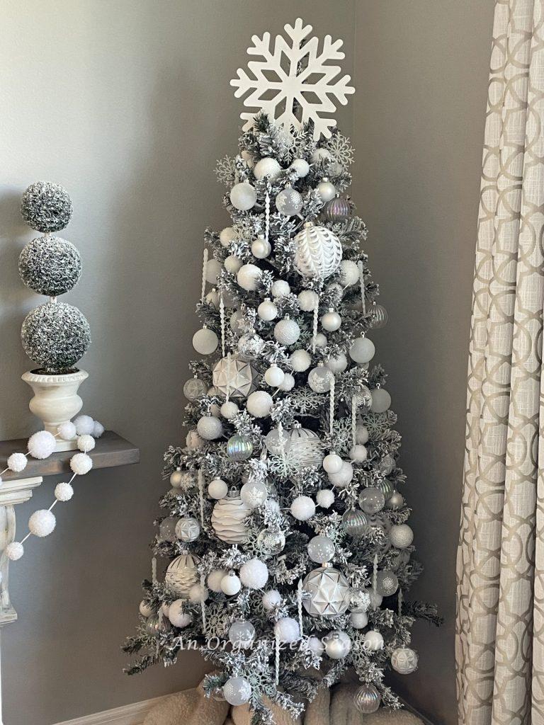 A small tree decorated in white snow themed ornaments adds a little bit of Christmas to the kitchen. 