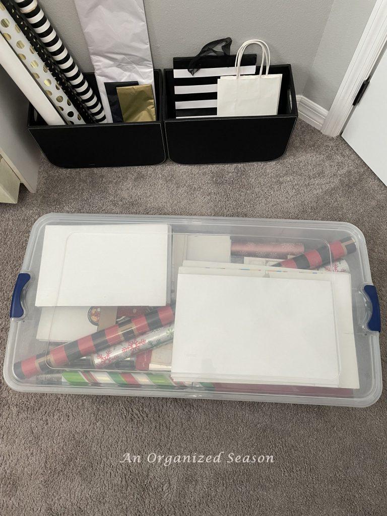 A plastic bin filled with wrapping paper and boxes.