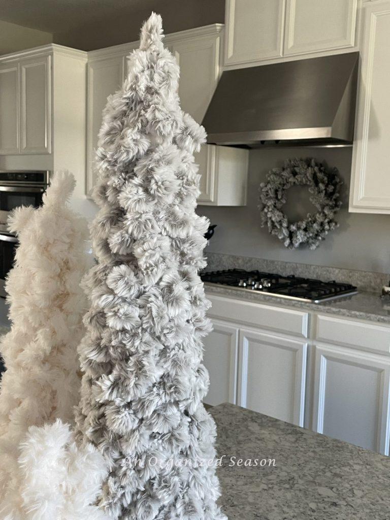 An evergreen flocked wreath hanging above a stove adds a little bit of Christmas to the kitchen.