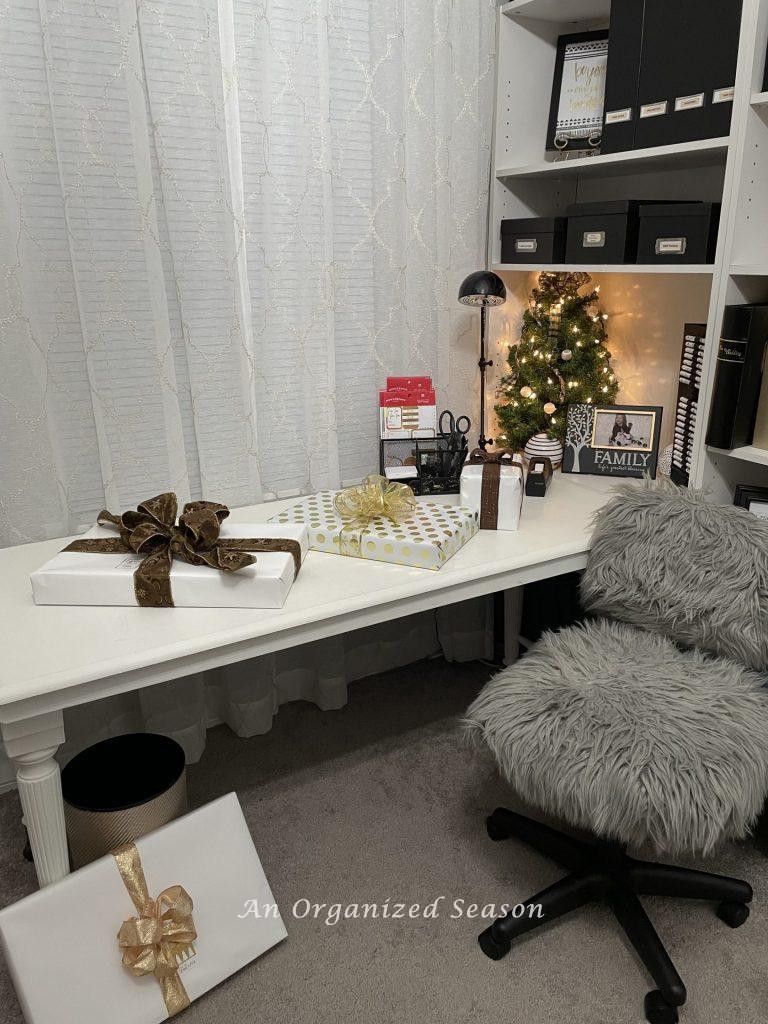 A white desk organized into a gift wrapping station. 