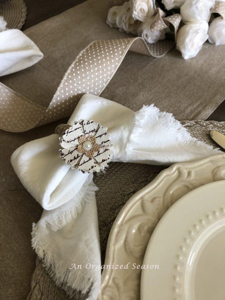 A white napkin that was tied in a bow being held by a floral napkin ring. My ninth most popular post of 2021. 