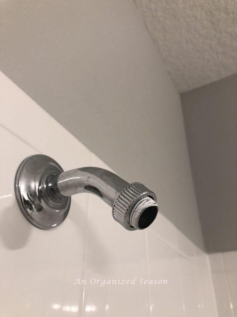 A luge nut screwed onto a shower pipe showing a step to easily install a new shower head. 