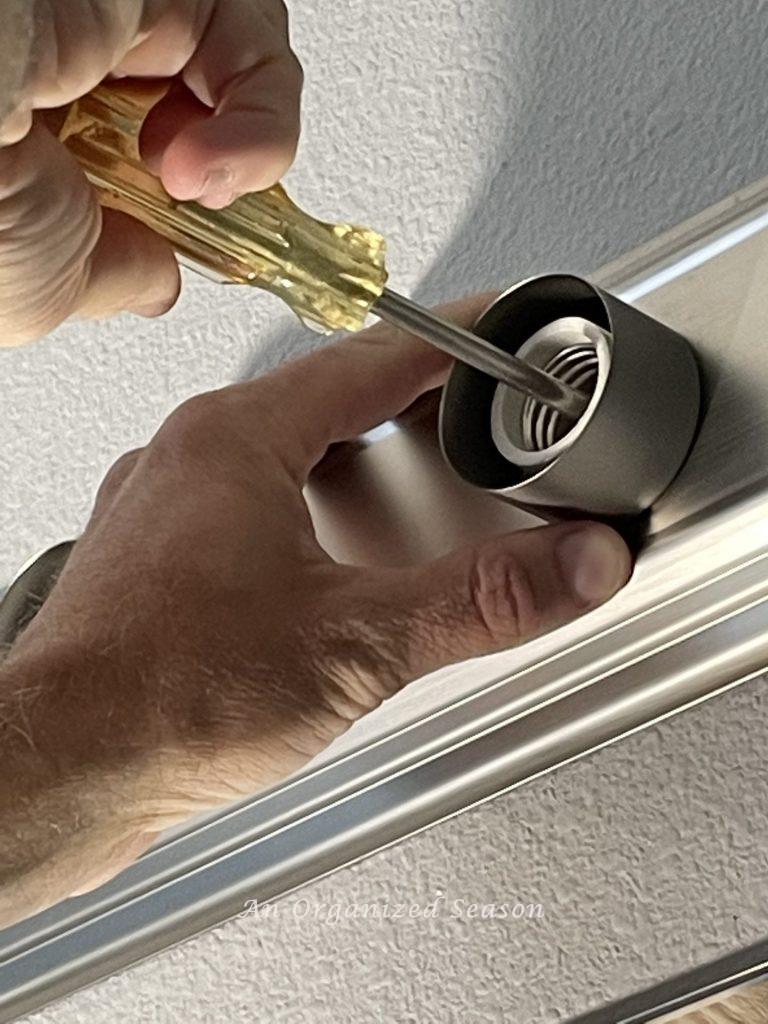 To replace a bathroom light fixture unscrew the old fixture from the wall.