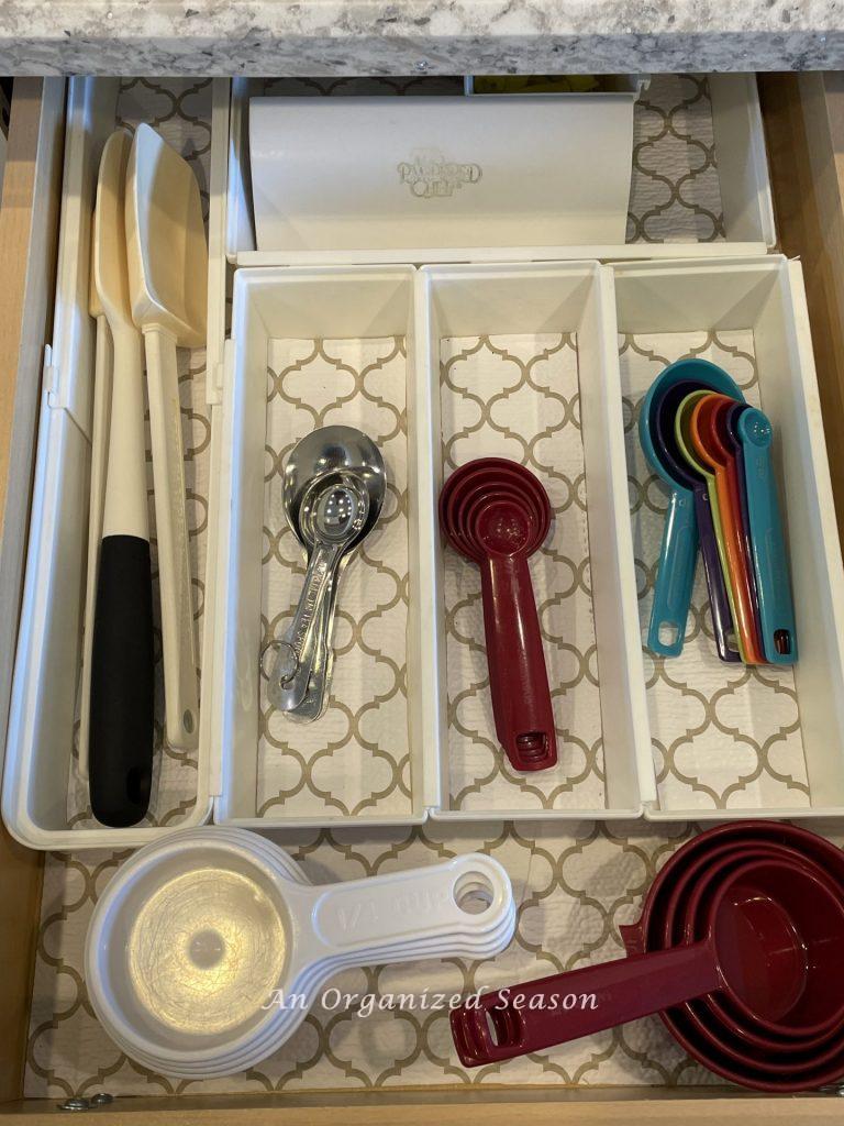 A utensil holder showing how to organize measuring cups and spoons in a kitchen drawer. 