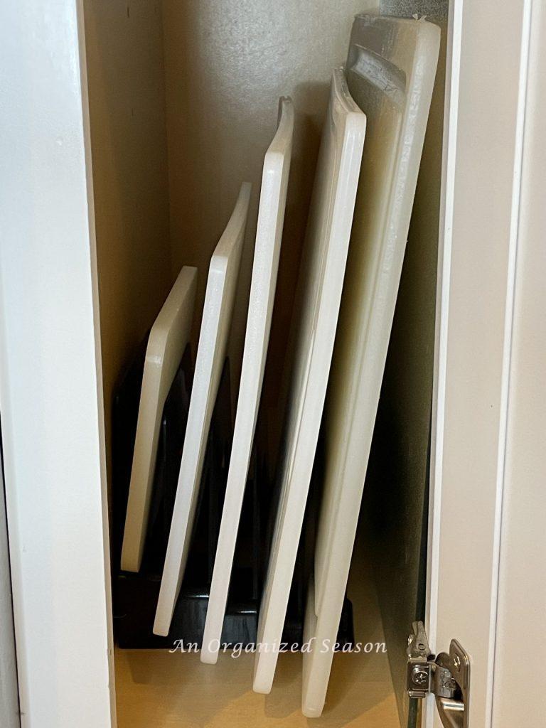 Using an incline file sorter to hold cutting boards is a  helpful kitchen cabinet organization solution!