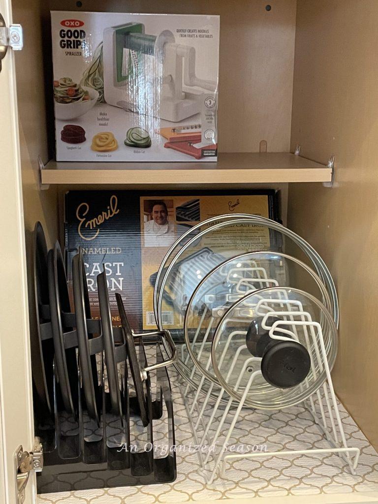 Using organizers for lids of pots and pans is a  helpful kitchen cabinet organization solution!