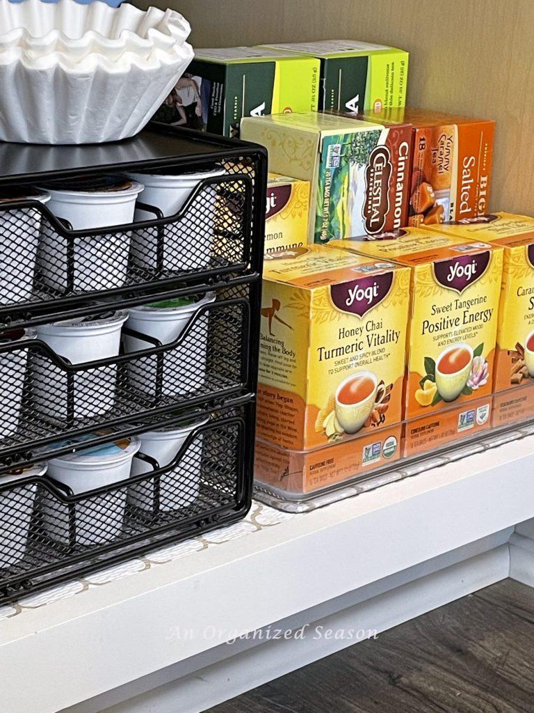 A coffee pod mesh organizer and a tiered tray for tea are  helpful kitchen cabinet organization solutions!