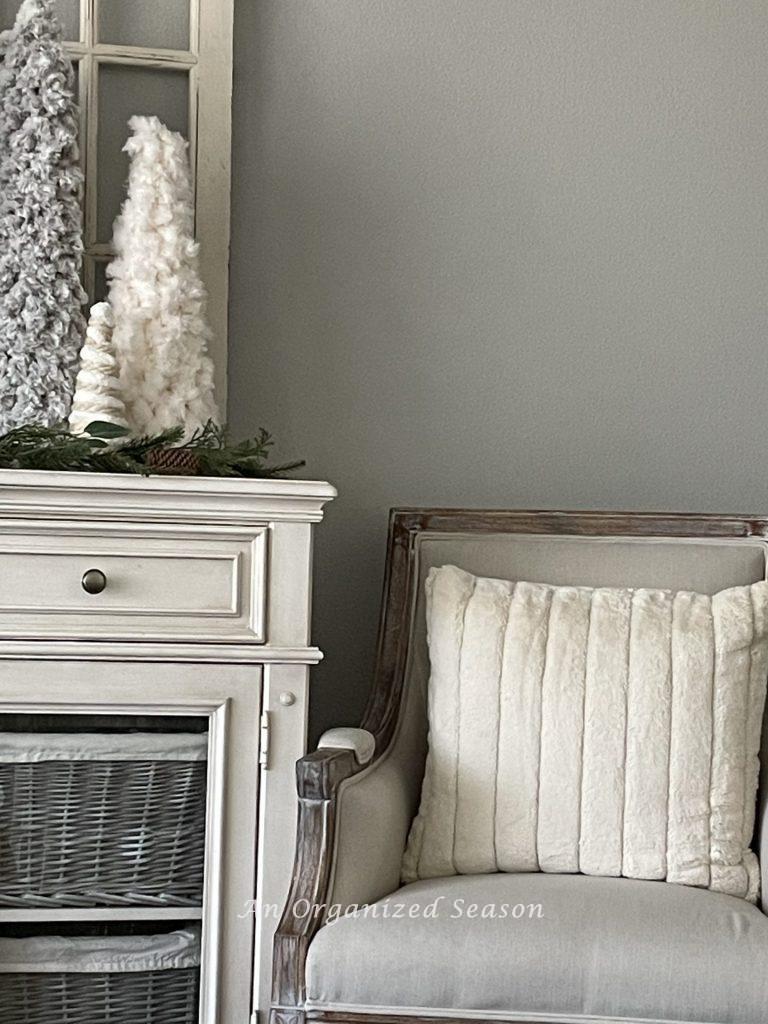 A chair with a large white faux fur pillow used to decorate a home for Winter.
