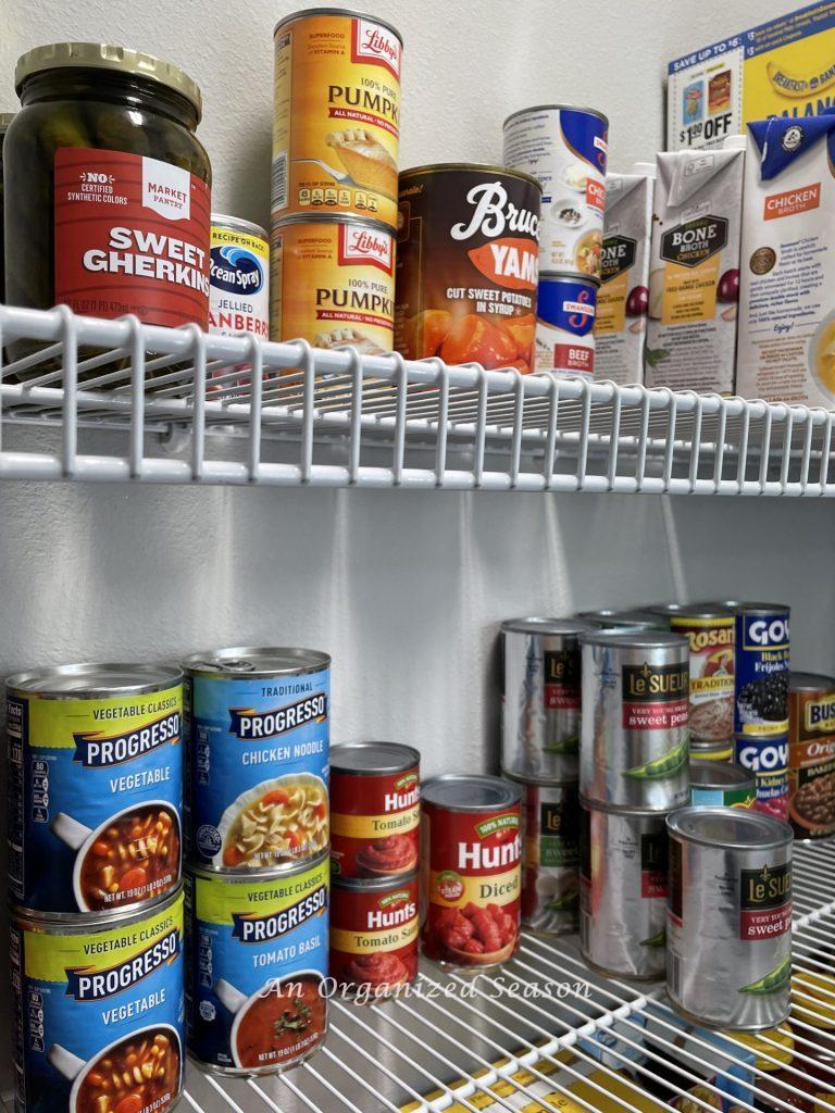 A clever tip to organize your pantry is to group similar canned items together on a shelf.