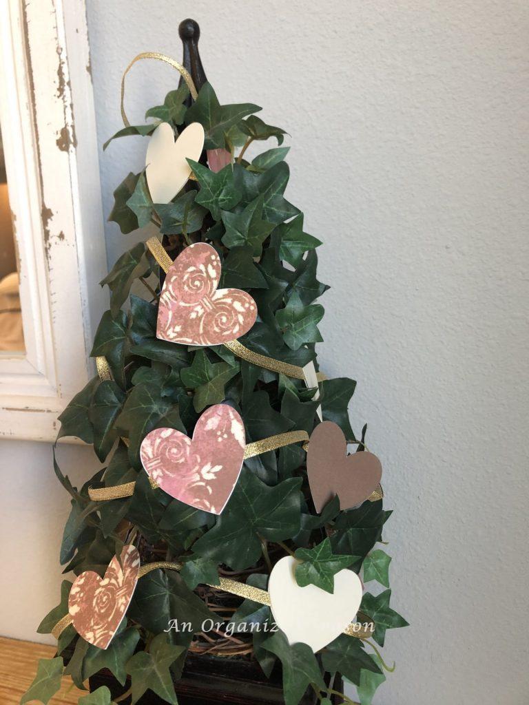 A paper heart and ribbon garland wrapped around a topiary!