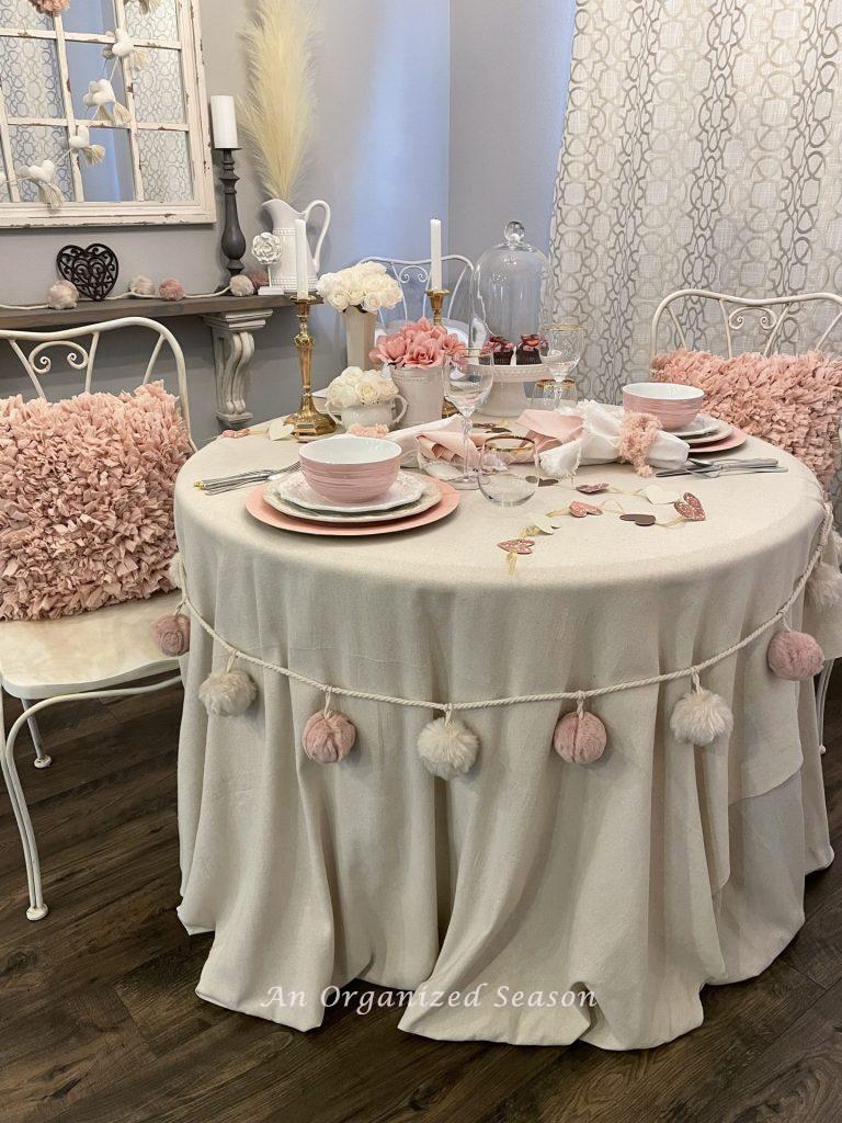 A kitchen table set with pink and white table decor for Valentine's Day!