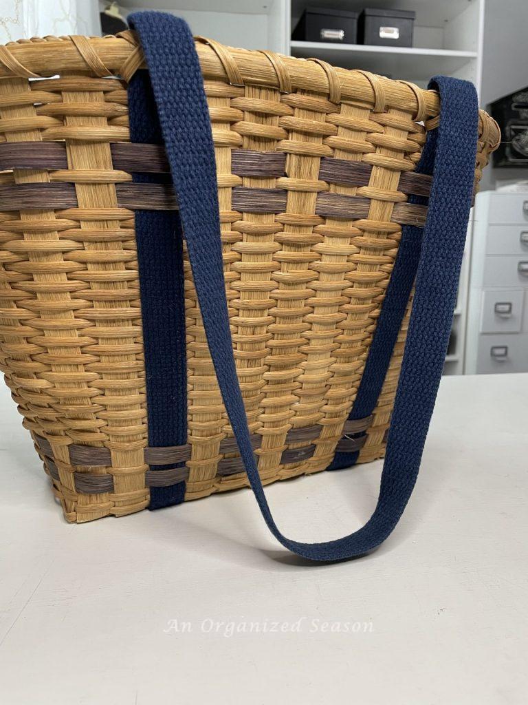 A tan basket with navy stripes and handles. First item needed to make a floral basket wreath.