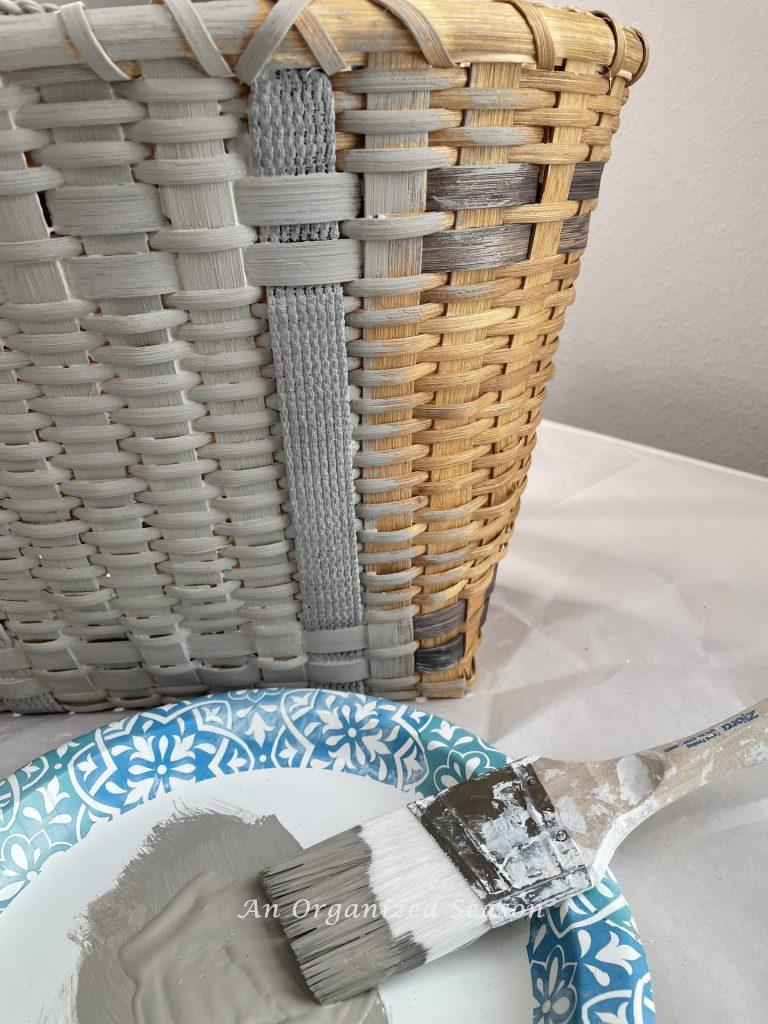 A basket being painted gray the first step to make a floral basket wreath.