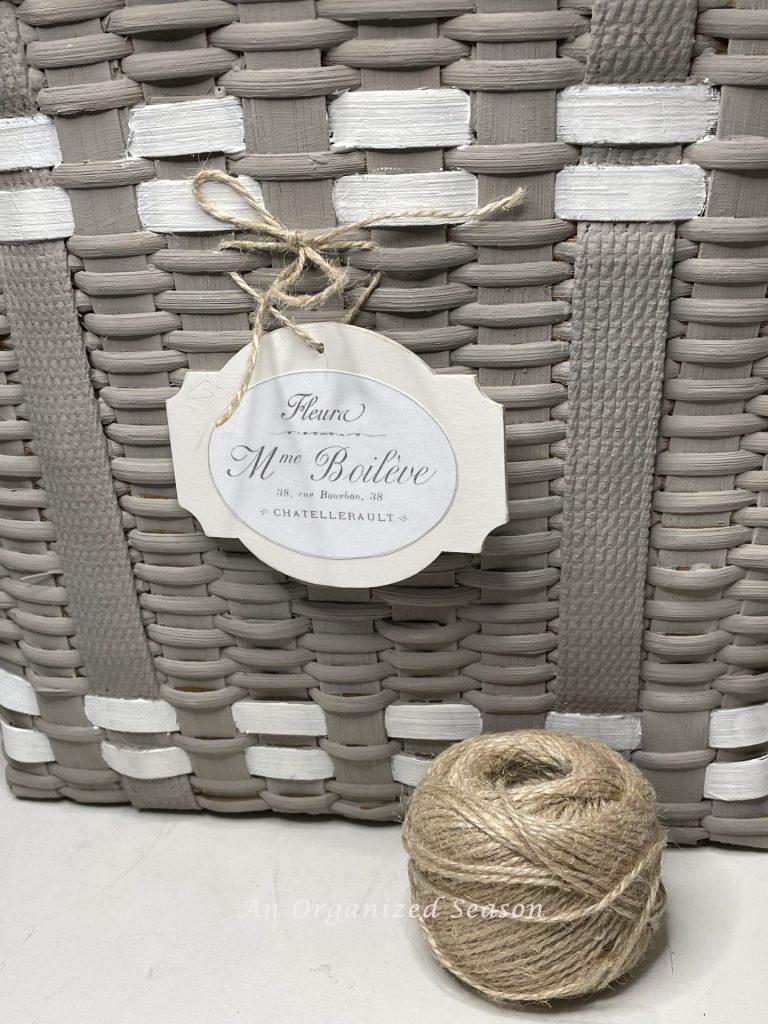 Attach tag to basket with jute twine, step six to make a floral basket wreath.