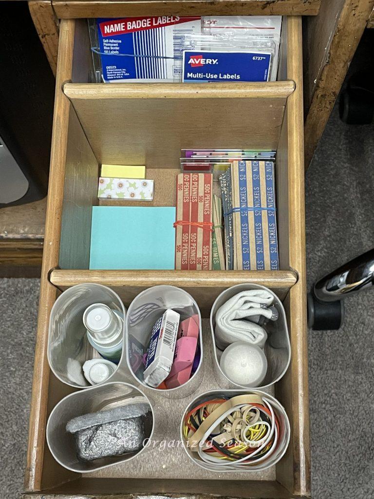A desk drawer that has Crystal Light containers as organizing bins, an example of ideas to organize a desk.