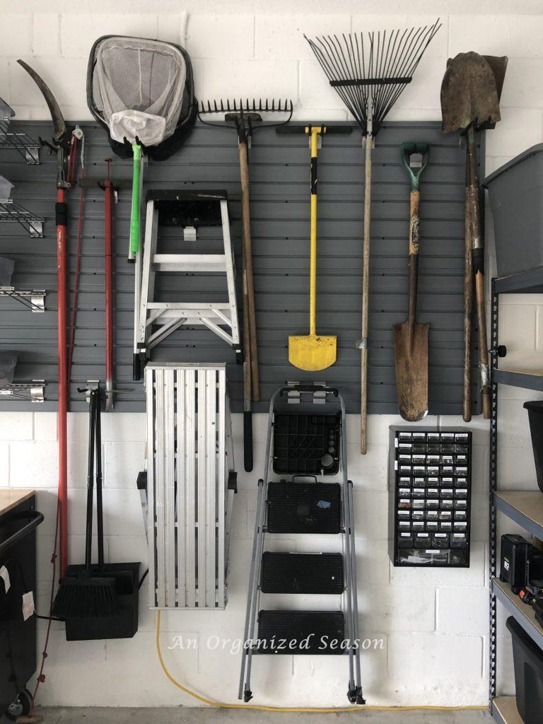 An organization system on a garage wall, showing tips for the  Spring Home Organization & Improvement Challenge.