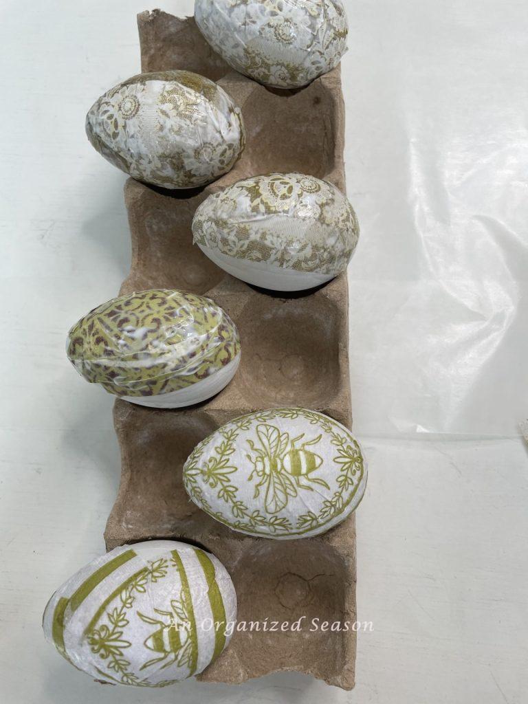 Eggs that have been covered in mod podge showing how to do a decoupage Easter egg DIY.