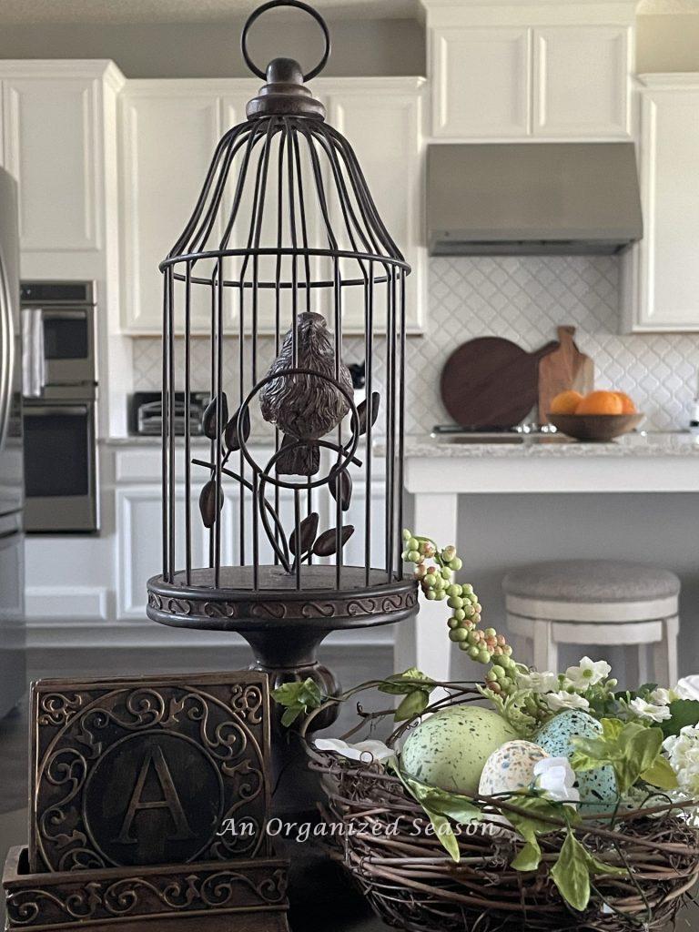 A brown faux birdcage sitting by a nest, showing ideas to decorate your home for Spring.