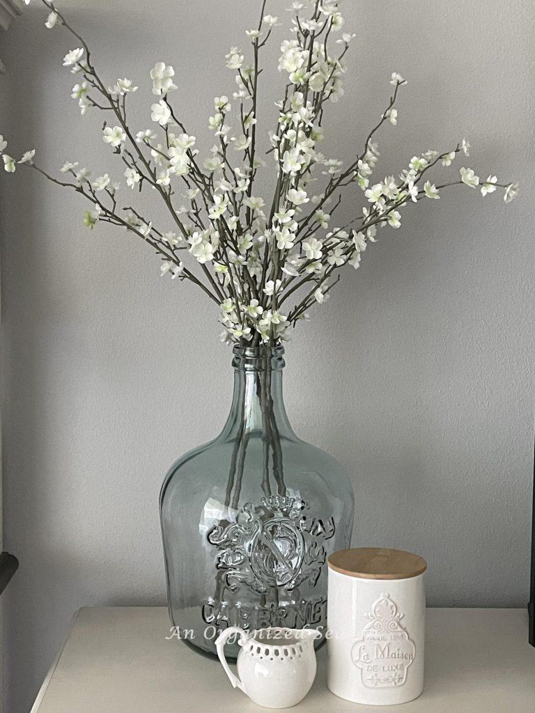 Dogwood branches in a large glass vase, an example of ideas to decorate your home for Spring. 