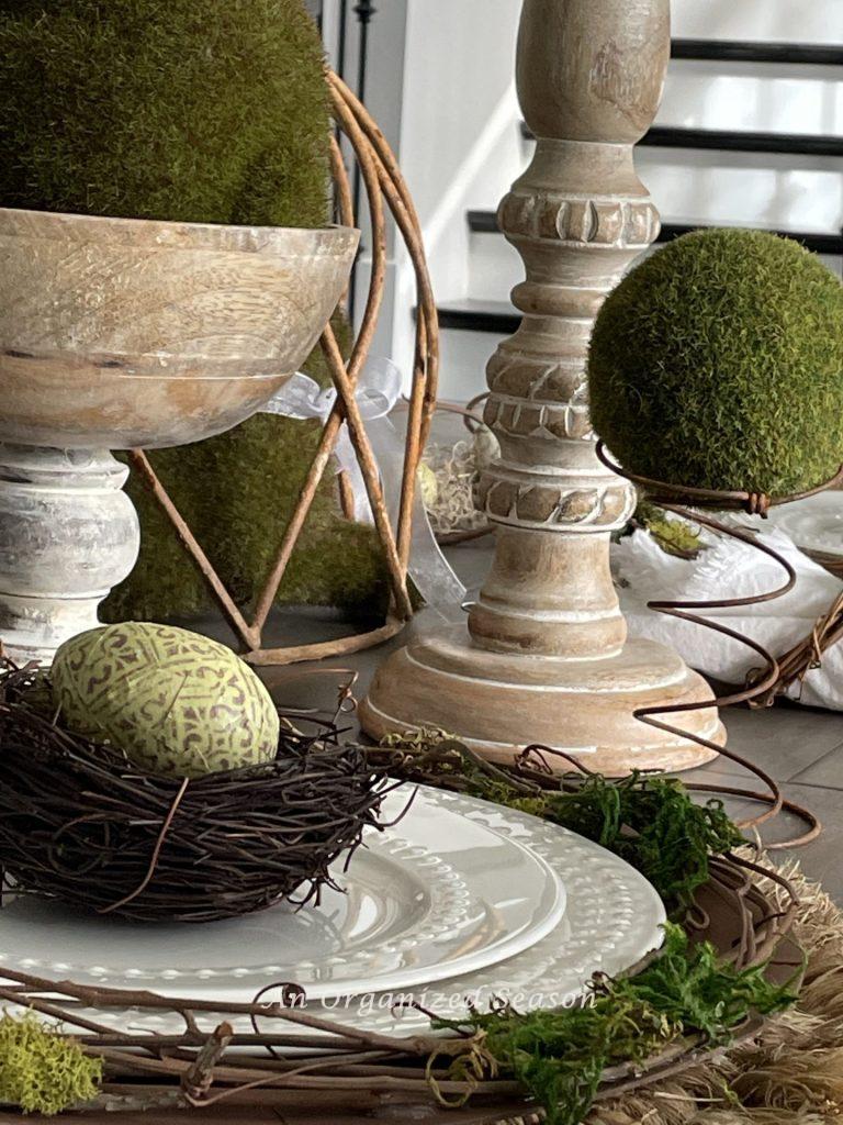 A decorated egg in a nest on a place setting, ideas to decorate your home for Spring.