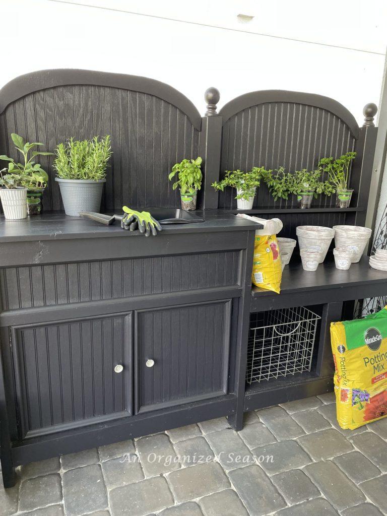 Potting bench with two counter heights showing one of 5 reasons to have an outdoor potting bench.