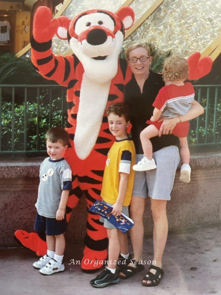 Family in a theme park with autograph book, a suggestion from the amusement park ultimate packing list.