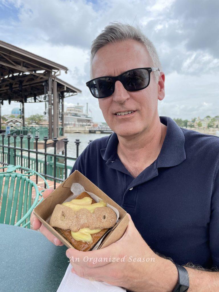 A dad holding a dessert that spells "d-a-d" on Father's Day.