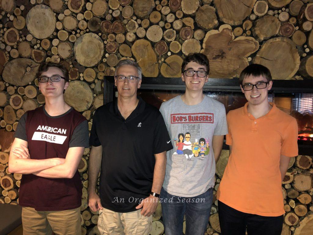 A dad and his three sons at a restaurant on Father's Day.