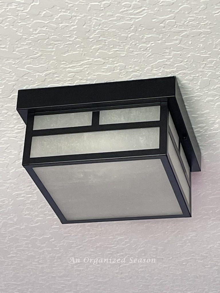 Black metal square ceiling light fixture is part of a  boring bedroom makeover for a gamer.