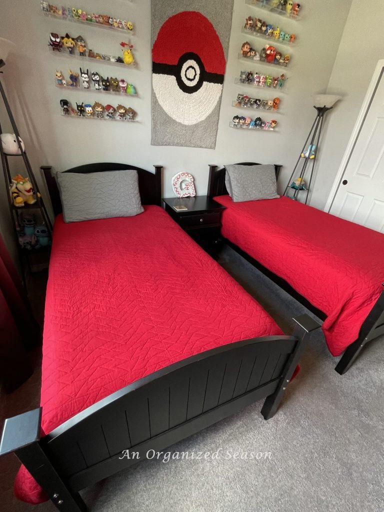 Black twin beds are the furniture for a  boring bedroom makeover for a gamer.