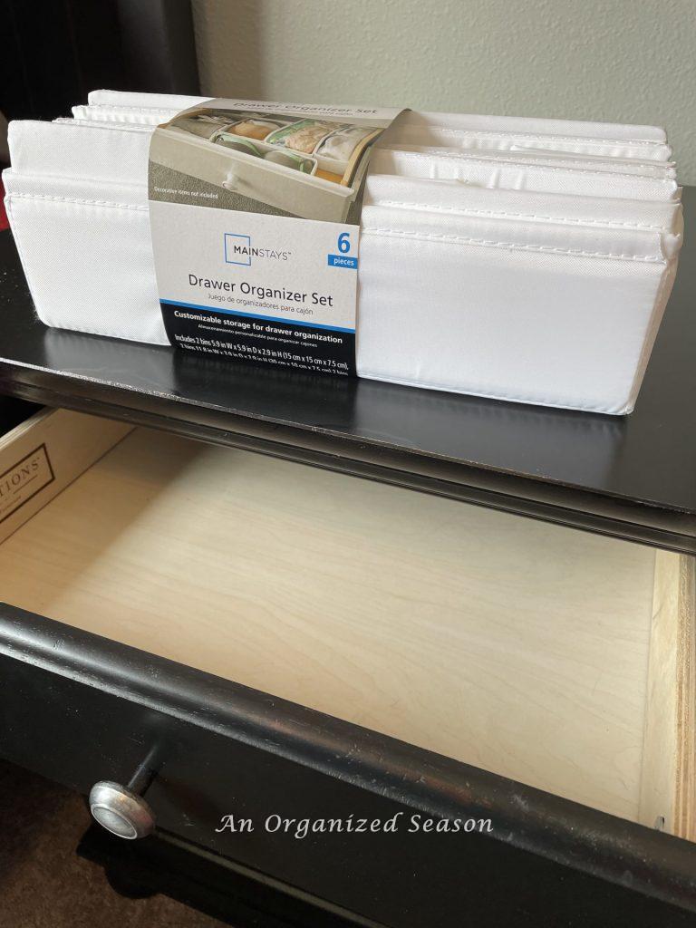 An empty drawer with a Drawer Organizer Set sitting on it, showing tips to organize collections in a kid's bedroom!