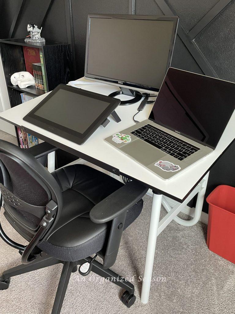 An organized desk holding two monitors and a laptop. 