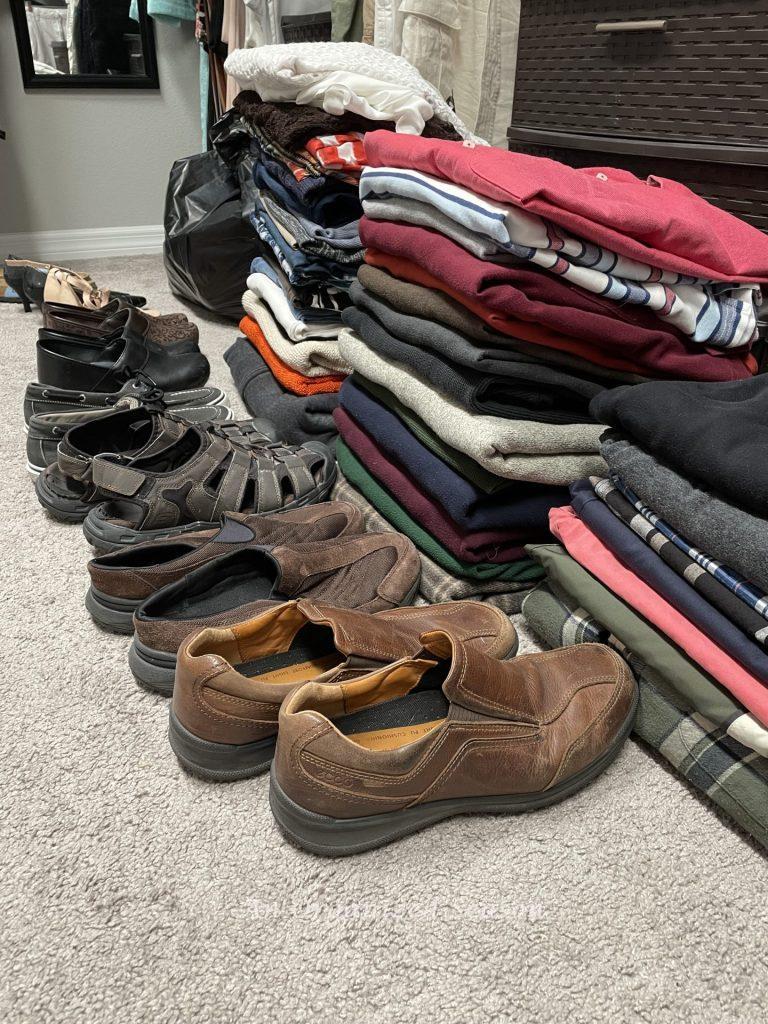 Four folded piles of clothes and several pairs of shoes, an example of how to purge your clothes. 