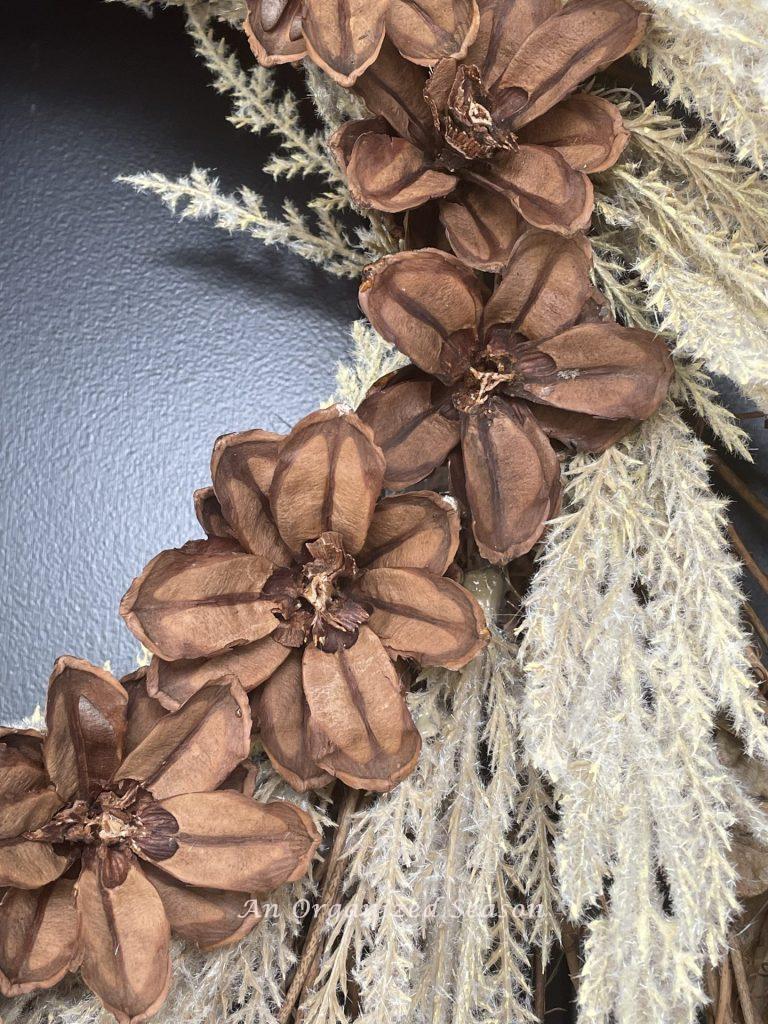 Close-up of four pinecone flowers on a wreath.