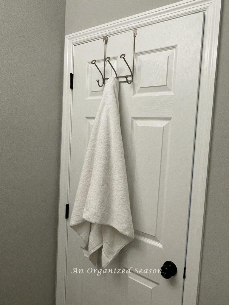 Use an over the door towel hook to organize a guest bathroom.