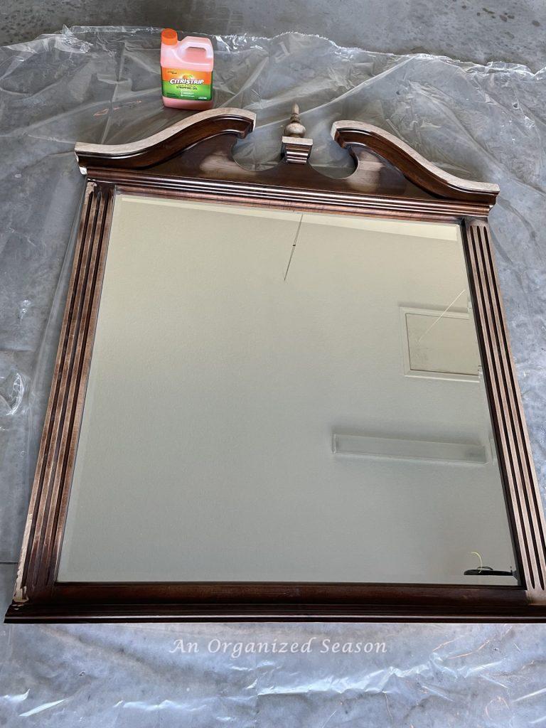 A wood mirror that has been partially sanded to remove the cherry stain. 