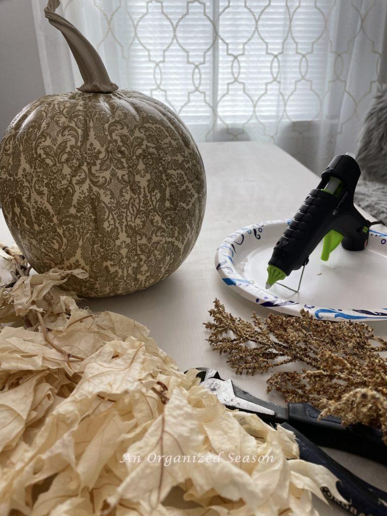 Hot glue stems onto your decoupage pumpkins.