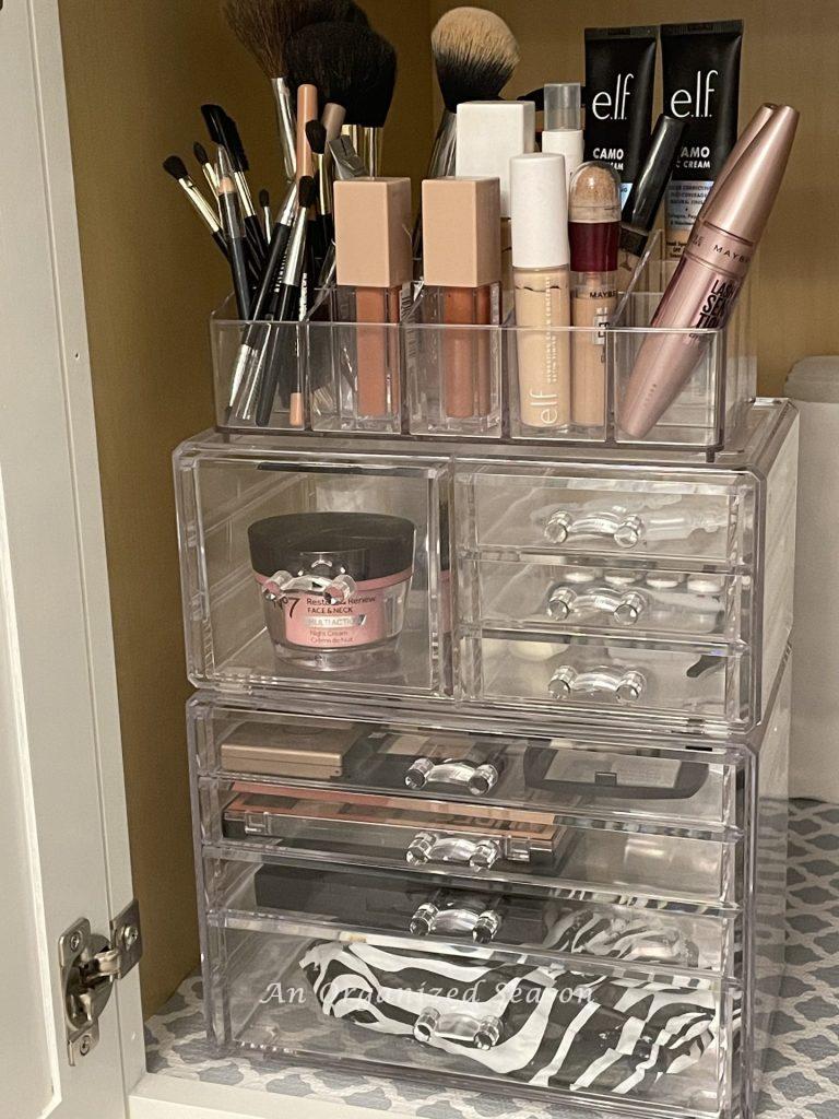 Clear acrylic storage organizers hold make-up in the bathroom.