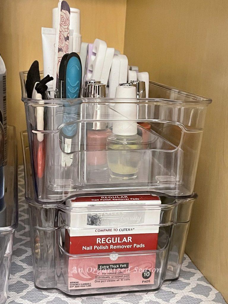 Clear stackable plastic bins provide storage for mani/pedi supplies in the bathroom.