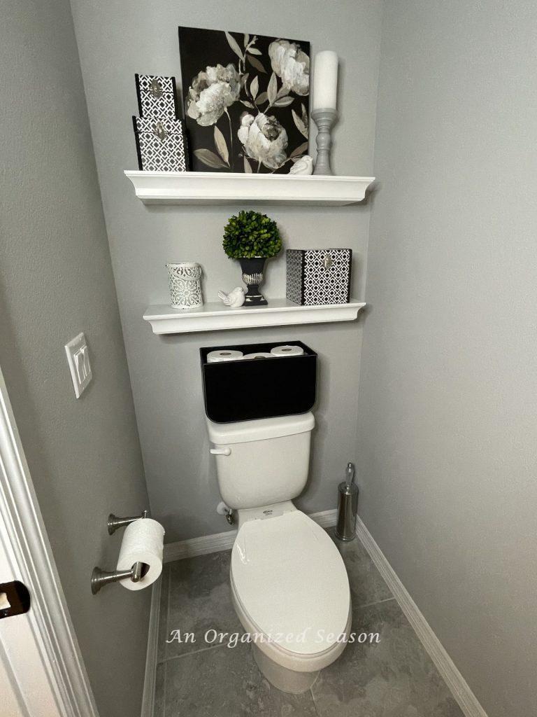 Two shelves in a water closet providing storage solutions in the bathroom. 