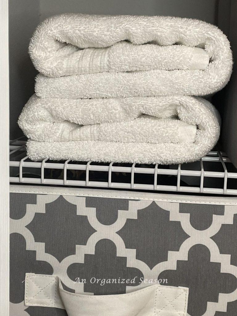 White towels folded neatly in a closet.