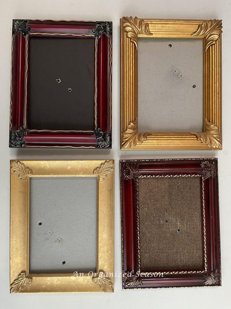 Four empty picture frames used to make DIY towel hooks.