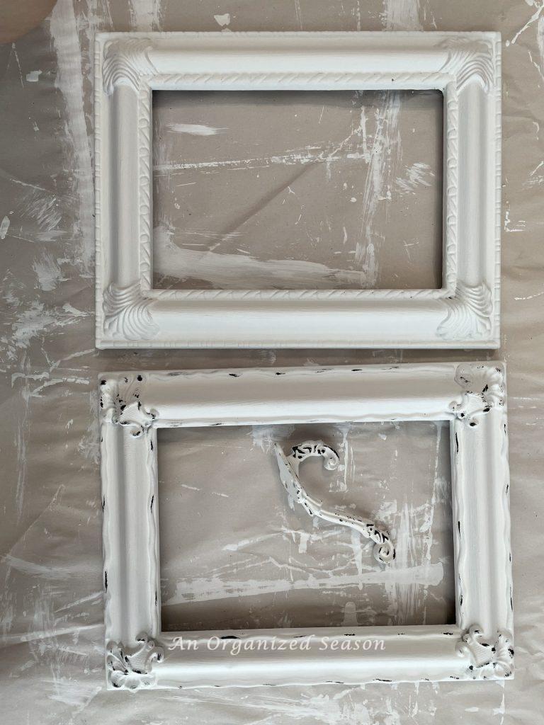 White frame next to another white frame that was distressed with black paint to match a hook.