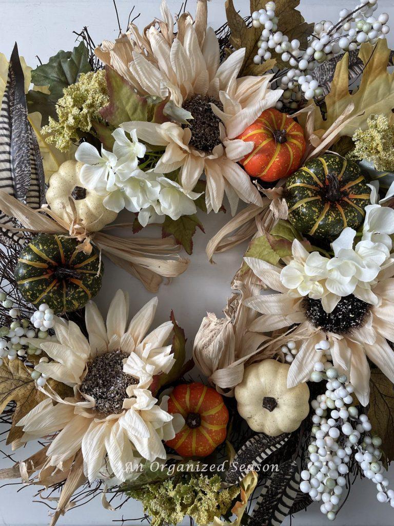 A fall wreath with orange and green pumpkins. Reuse this old wreath for a Budget decorating ideas for fall porch