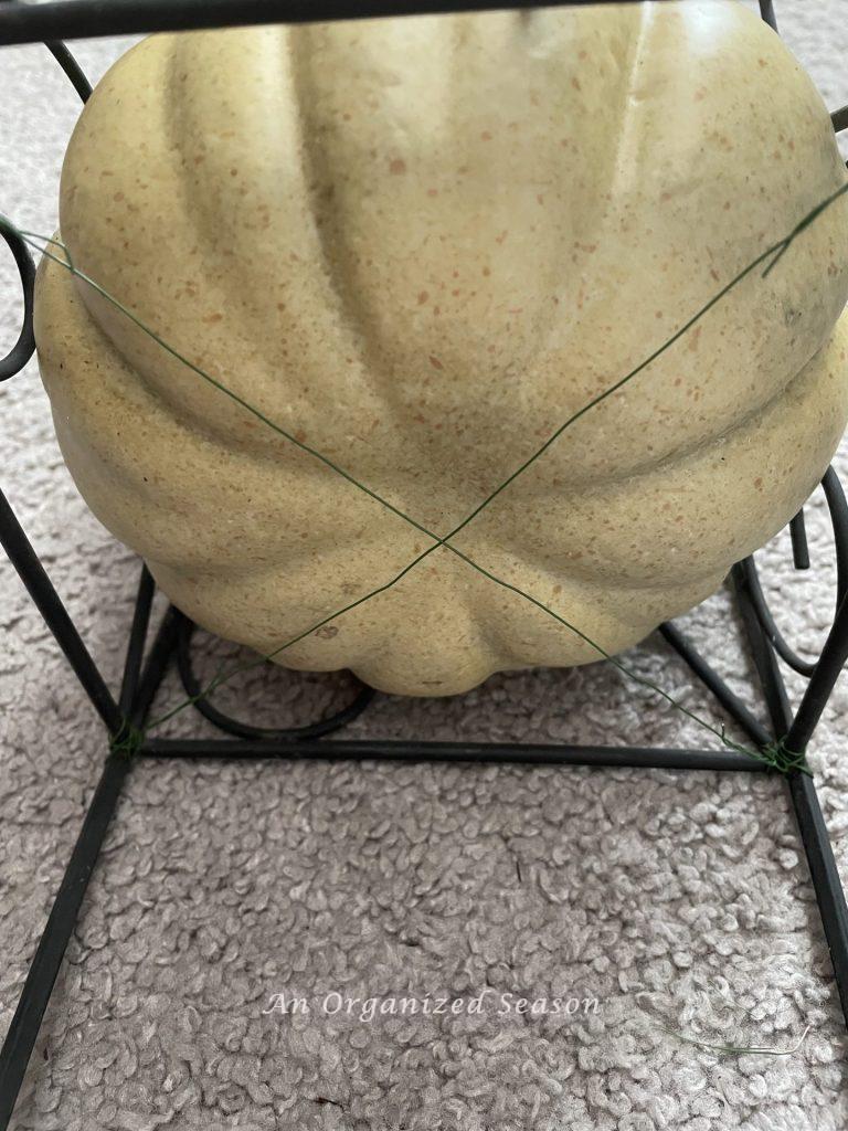 Floral wire in an "X" shape securing the bottom pumpkin in the obelisks.