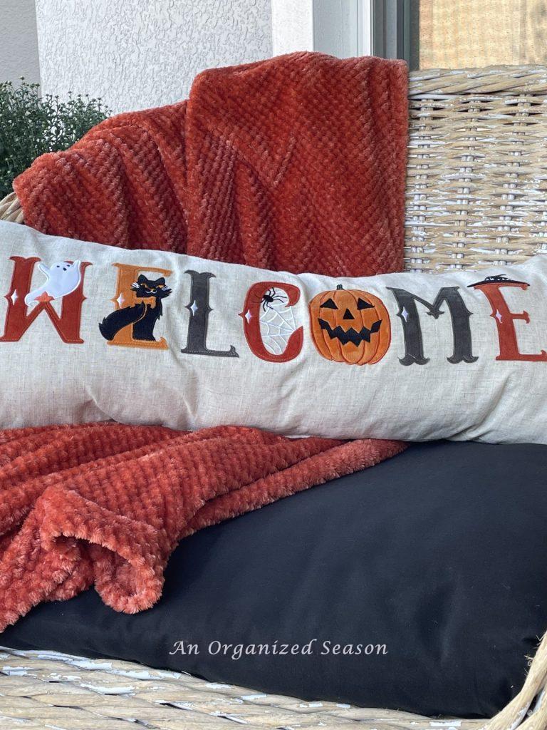 A throw burgundy blanket and Halloween pillow. Put them on an outdoor chair for a Budget decorating ideas for fall porch.