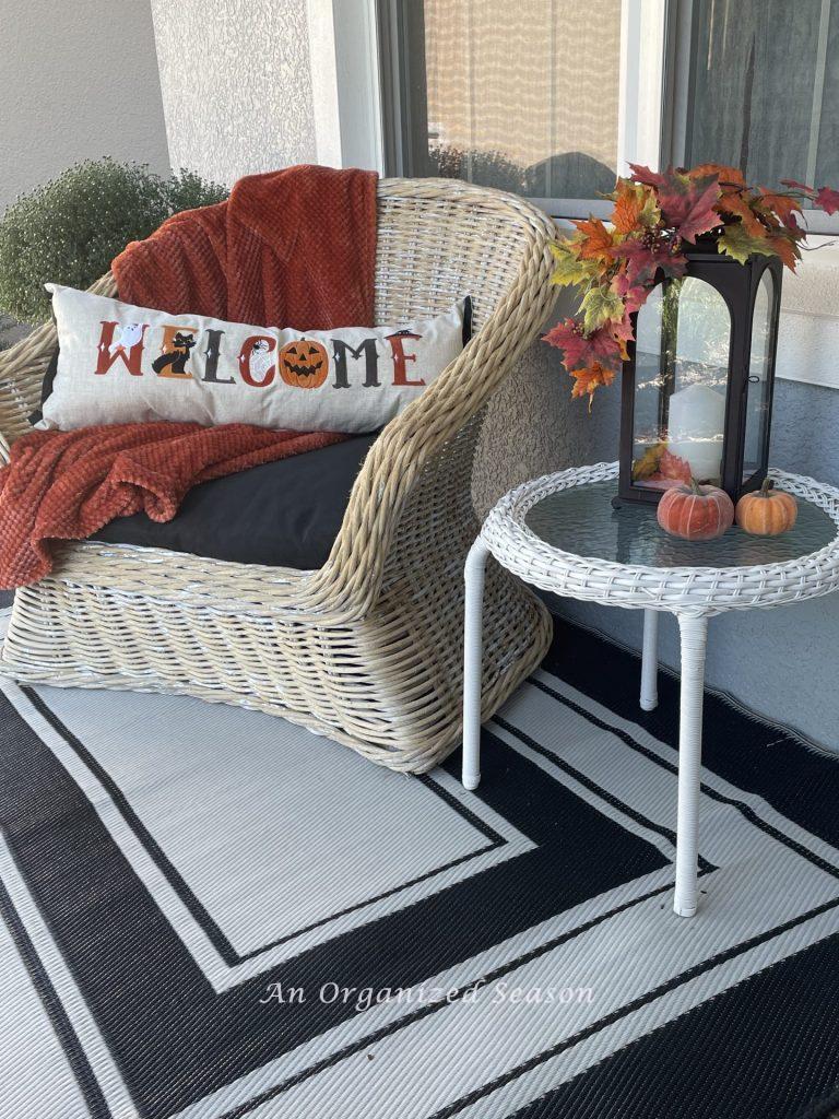 A porch chair decorated for fall. 